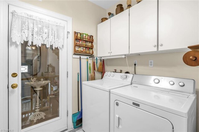 clothes washing area featuring cabinet space and independent washer and dryer