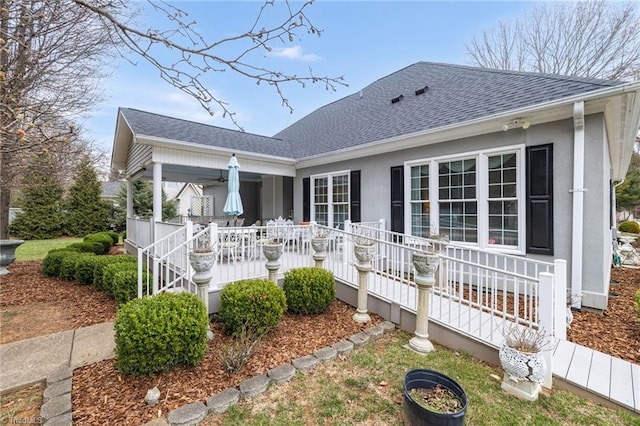 back of house with a porch and a shingled roof