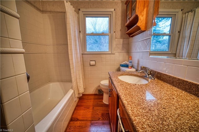 full bathroom featuring tile walls, shower / bathtub combination with curtain, toilet, vanity, and wood finished floors