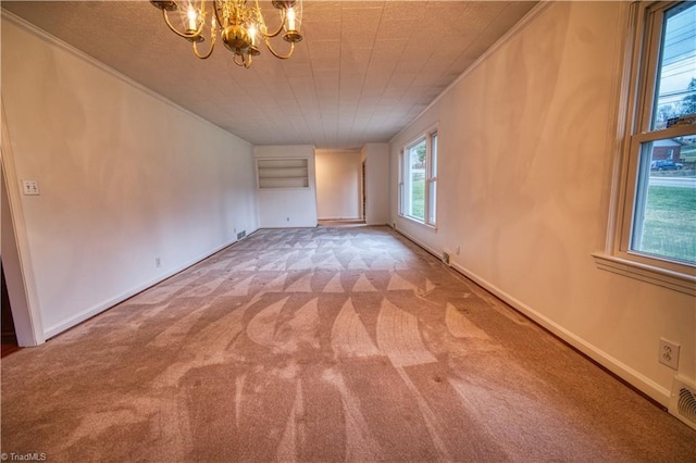 empty room featuring baseboards, crown molding, carpet, and an inviting chandelier