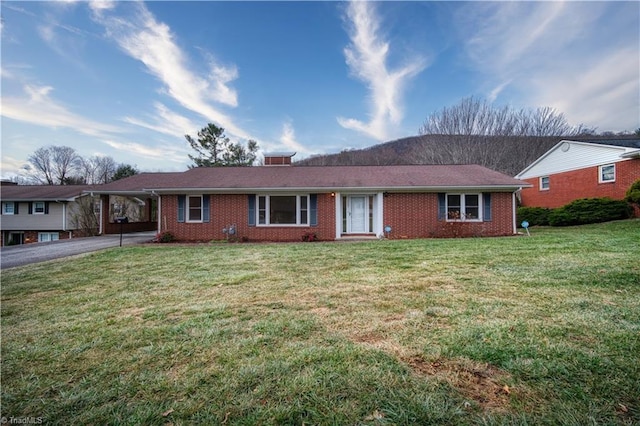 single story home featuring aphalt driveway, an attached carport, a front yard, and brick siding