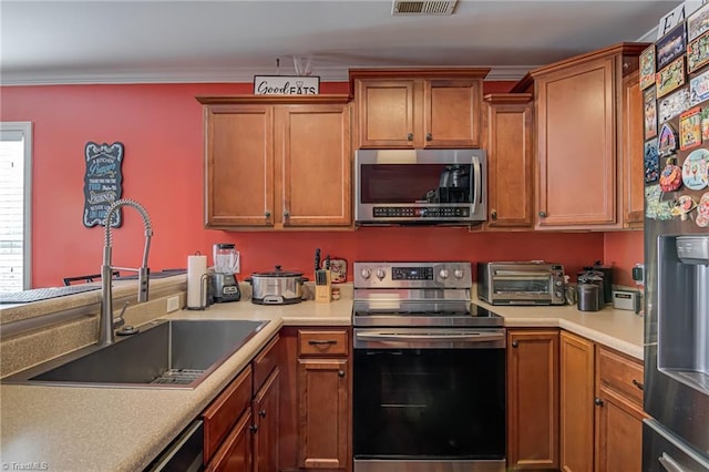 kitchen with sink, crown molding, and stainless steel appliances