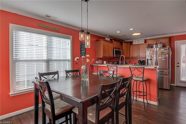 dining room with dark wood-type flooring and crown molding