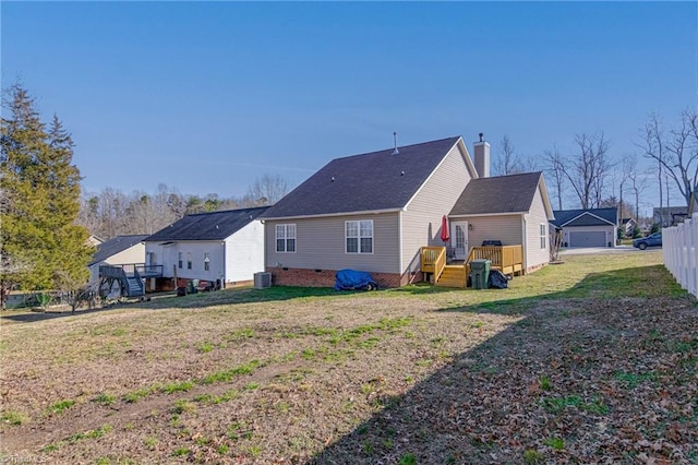 back of house featuring central air condition unit, a deck, a garage, and a lawn