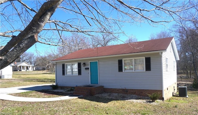 view of front of property with central AC unit and a front yard