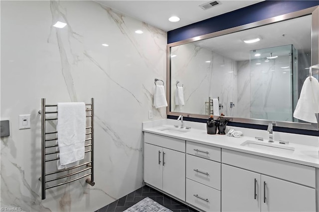 400 W 4th St Unit 305, Winston-Salem, NC 27101 - bathroom featuring radiator heating unit, a towel warmer, a marble finish shower, and double vanity