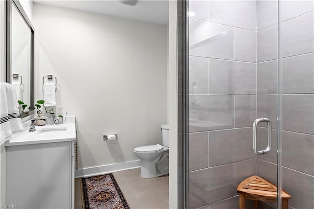400 W 4th St Unit 305, Winston-Salem, NC 27101 - bathroom featuring toilet, vanity, a stall shower, baseboards, and tile patterned flooring