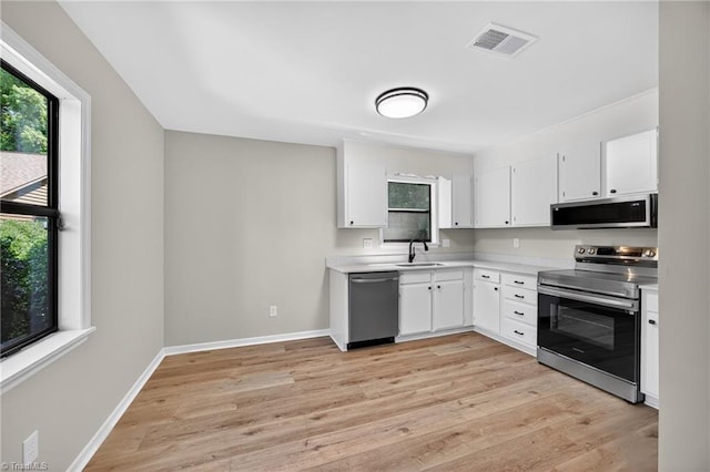 1814 Guyer St Unit A, High Point, NC 27265 - kitchen featuring stainless steel appliances, a sink, light countertops, white cabinetry, and light wood-style floors