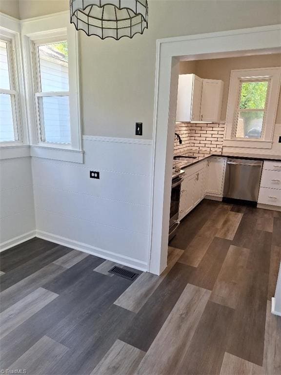 kitchen featuring stainless steel appliances, a wealth of natural light, dark hardwood / wood-style floors, and white cabinets