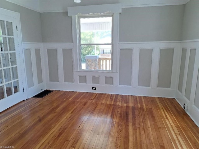 spare room with ornamental molding and hardwood / wood-style flooring