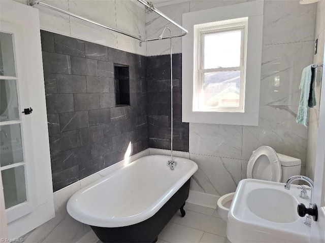 full bathroom with sink, toilet, tile walls, tiled shower / bath, and tile patterned flooring