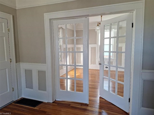 doorway with dark wood-type flooring, crown molding, and plenty of natural light