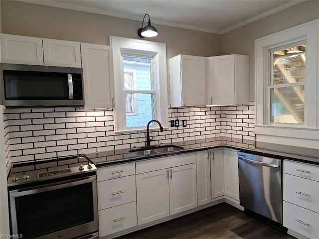 kitchen with appliances with stainless steel finishes, sink, and white cabinets