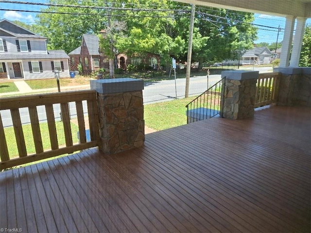 wooden terrace featuring a yard and covered porch