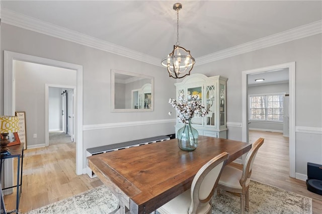 dining room with a chandelier, light hardwood / wood-style flooring, and ornamental molding