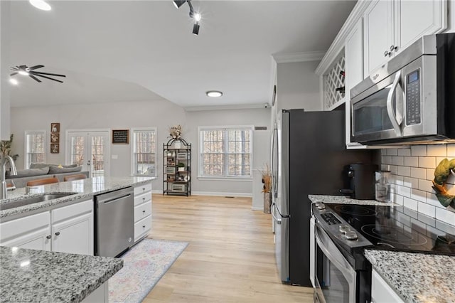 kitchen featuring white cabinets, decorative backsplash, stainless steel appliances, and sink