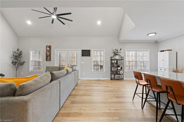 living room with ceiling fan, lofted ceiling, french doors, and light hardwood / wood-style flooring