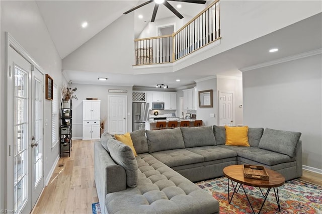 living room featuring ceiling fan, high vaulted ceiling, light hardwood / wood-style floors, and ornamental molding