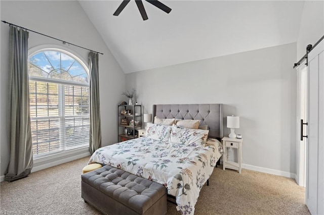 carpeted bedroom with a barn door, ceiling fan, and vaulted ceiling