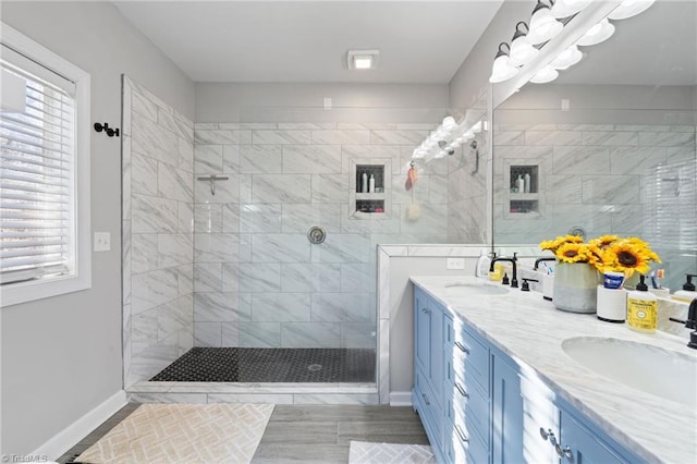 bathroom featuring a tile shower and vanity