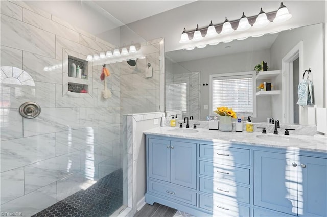 bathroom featuring a tile shower and vanity