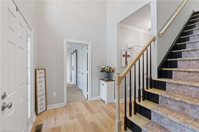 foyer entrance featuring ornamental molding and light hardwood / wood-style flooring