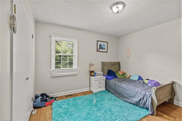124 Jacklyn Ct, High Point, NC 27265 - bedroom featuring wood finished floors, a textured ceiling, and baseboards