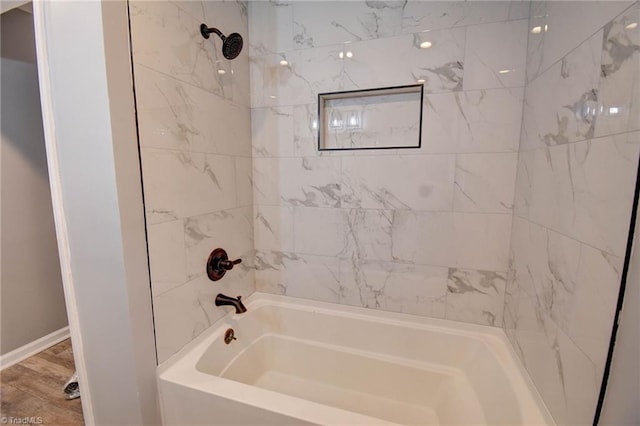 bathroom with tiled shower / bath and hardwood / wood-style flooring