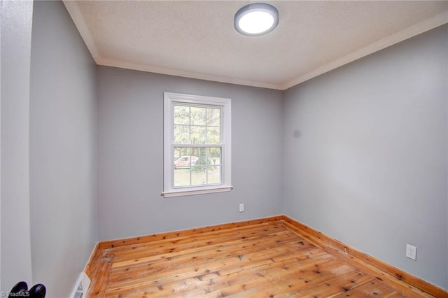 spare room featuring hardwood / wood-style flooring and crown molding