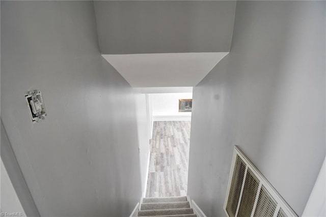 staircase with hardwood / wood-style floors