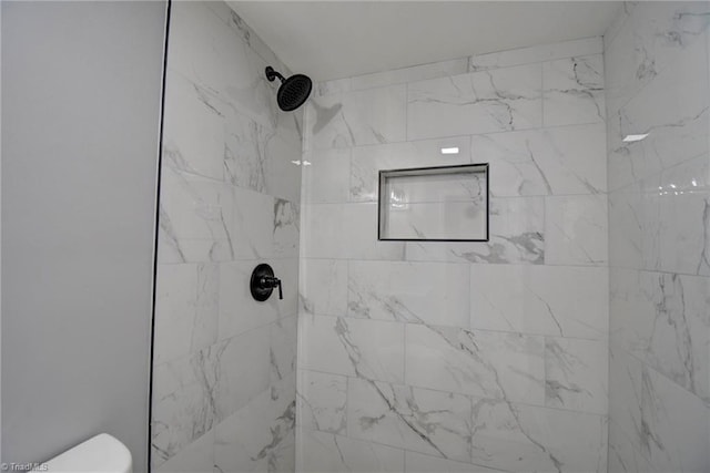 bathroom featuring toilet and tiled shower