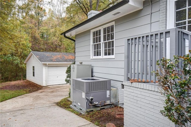 view of home's exterior with a garage, central air condition unit, and an outbuilding