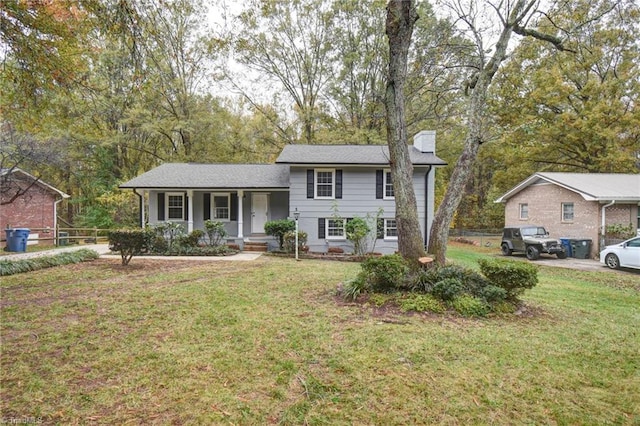 split level home featuring covered porch and a front lawn