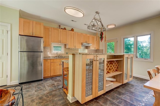 kitchen featuring visible vents, freestanding refrigerator, a sink, and light brown cabinets