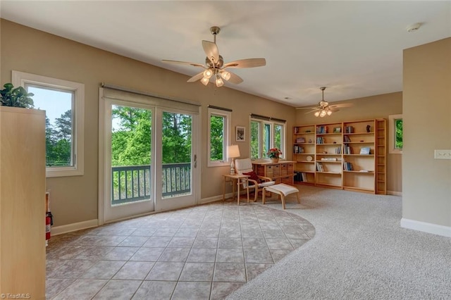 living area featuring baseboards and ceiling fan