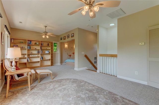 living area with a ceiling fan, baseboards, visible vents, and light carpet