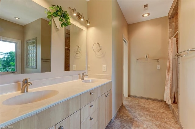 full bathroom featuring a sink, baseboards, double vanity, and visible vents