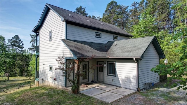rear view of house featuring a patio and a shingled roof