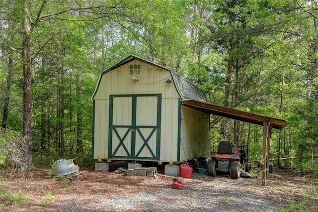 view of shed with a forest view and a carport