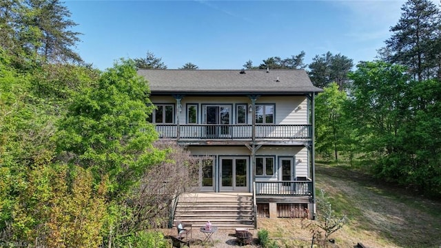 rear view of property featuring a wooden deck and a balcony