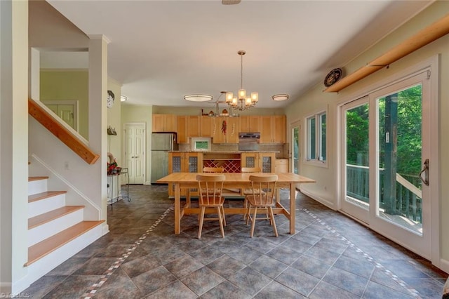 dining area with baseboards, an inviting chandelier, and stairway
