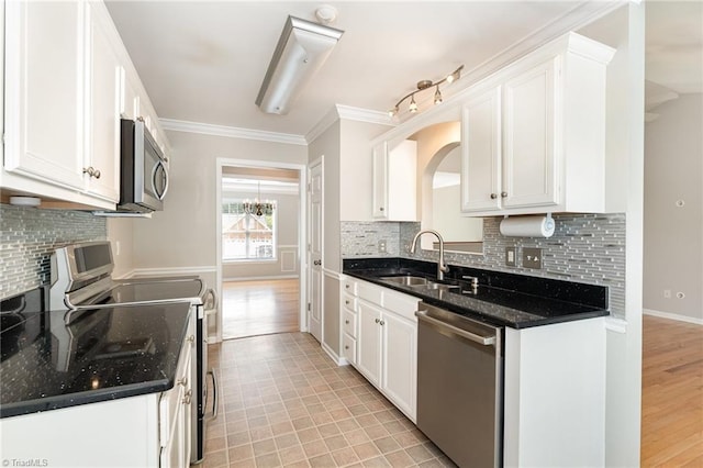 5921 Election Oak Dr, High Point, NC 27265 - kitchen with stainless steel appliances, a sink, white cabinets, decorative backsplash, and ornamental molding