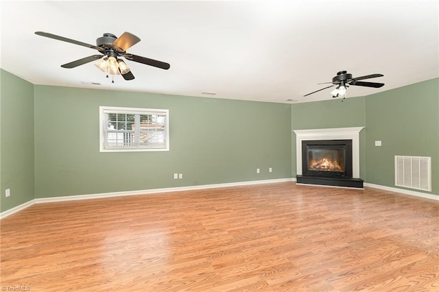 5921 Election Oak Dr, High Point, NC 27265 - unfurnished living room featuring ceiling fan, light wood finished floors, a glass covered fireplace, and baseboards