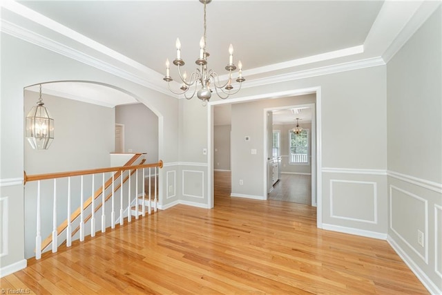 5921 Election Oak Dr, High Point, NC 27265 - unfurnished room with a chandelier, light wood-style flooring, crown molding, arched walkways, and a decorative wall