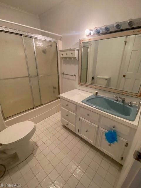 full bathroom featuring vaulted ceiling, combined bath / shower with glass door, tile patterned flooring, vanity, and toilet