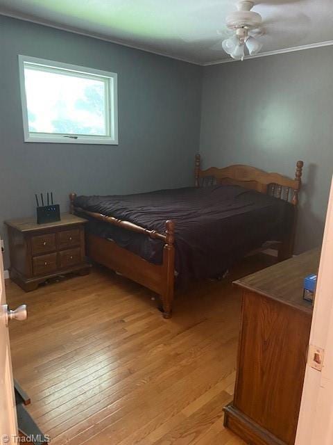 bedroom featuring ornamental molding, ceiling fan, and light hardwood / wood-style flooring