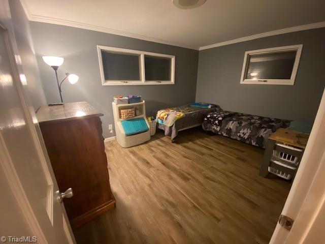 bedroom featuring crown molding and wood-type flooring