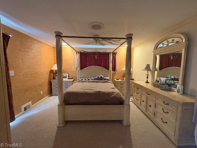 bedroom featuring visible vents, crown molding, and light carpet