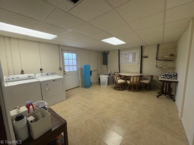 clothes washing area featuring electric panel and washer and clothes dryer