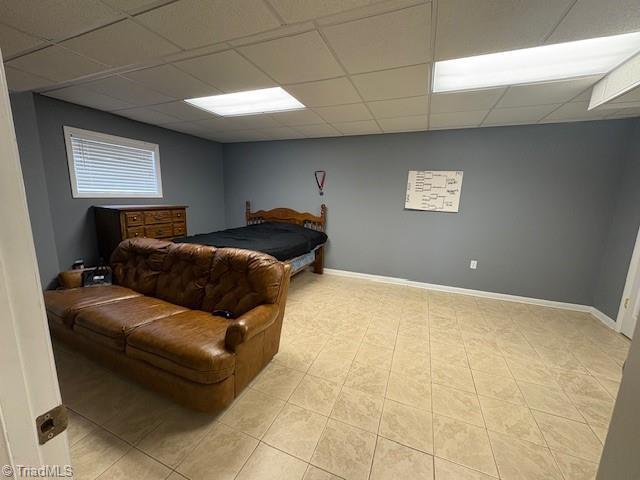 bedroom with baseboards and a drop ceiling